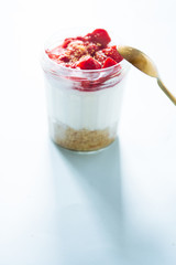 Tiramisu cheesecake with strawberry  in glass on a blue board, natural backlight