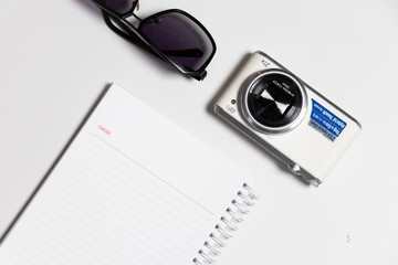 Top view not book camera and sunglasses on flat lay