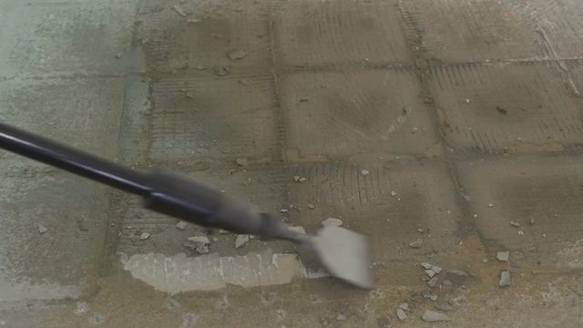Using an air hammer to remove old flooring on a house remodel