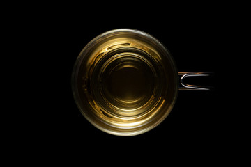 Top view of a glass cup of mint tea isolated on black background