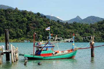 Fototapeta na wymiar Thai fishing boat at wooden pier on the Koh Chang island, Thailand.