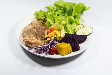 Salad with grilled chicken on white plate.