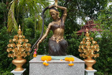 Chiang Mai Thailand, Phra Mae Thorani statue with offerings in garden at Wat Pan Ping