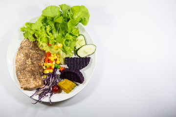 Salad with grilled chicken on white plate.