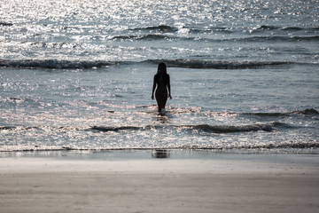 silhouette of a naked girl coming out of the sea