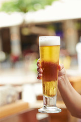 Hand holding glass of beer 