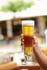 Hand holding glass of beer 