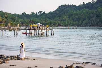 Asian woman on the beach the background sea and a wooden bridge at Koh Kood, Trat in Thailand.
