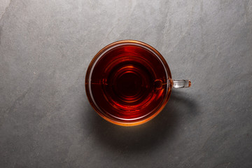 Top view photo of a black tea cup over a stone background