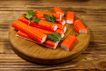 Crab sticks on cutting board on wooden table