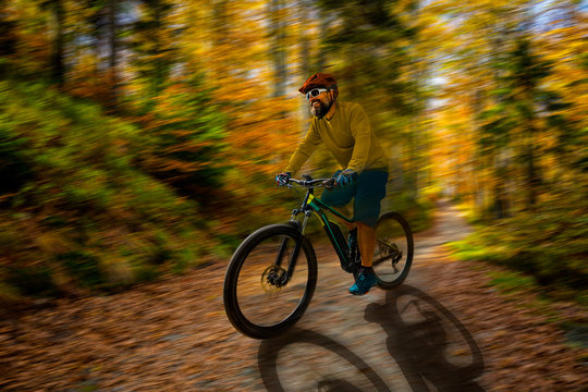 Mountain biker riding on bike in spring mountains forest landscape. Man cycling MTB enduro flow trail track. Outdoor sport activity. Motion Blur picture.