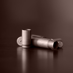 Old bullet cartridges on a dark background close up. Brown color toned