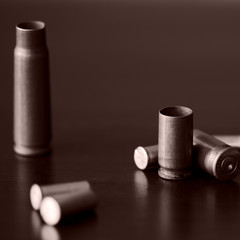 Old bullet cartridges on a dark background close up. Brown color toned
