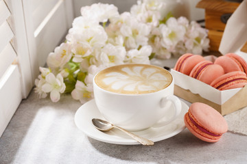 Cup of coffee and french macarons. Natural sunlight.