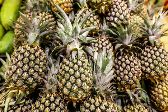 Ripe pineapples. Outdoor food market. Juicy tropical fruits. Healthy organic food. Bali island.