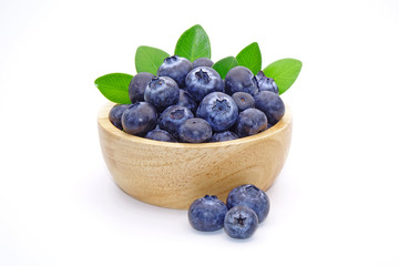 Blueberry : fresh blueberries with green leaves in wooden bowl isolated on white background.
