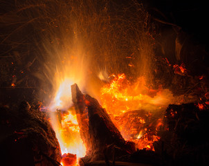 Burning fire in the night. Flame and fire sparkles on a dark abstract background. Hellish element...