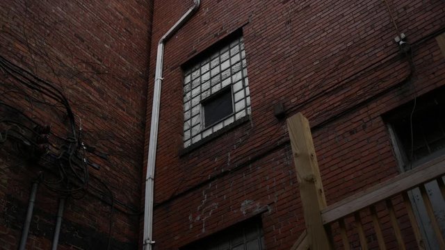 An old window in an abandoned industrial building a seen from alley