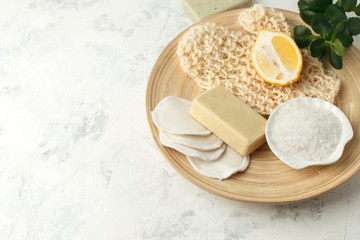 Top view of organic spa skincare bodycare products - lemon, sea salt, soap, zero waste sponge, massage gloves on wooden plate - minimal stylish spa wellness background