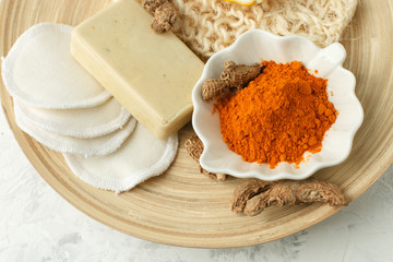 health body care concept. Raw organic orange turmeric root and powder, curcuma longa on wooden plate. Indian oriental low cholesterol spices, homemade cosmetic
