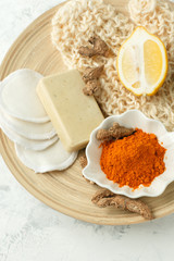 Dried turmeric roots and powder in ceramic bowl and ingredient and treatment for homemade spa procedures. Grey background. Top view. Copy space.