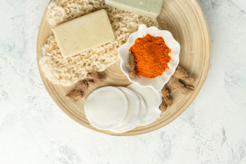 Ingredients for Face Mask with turmeric powder, spa procedures for skin health. Organic wellness treatment - curcumin powder, soap, sponge, natural massage gloves