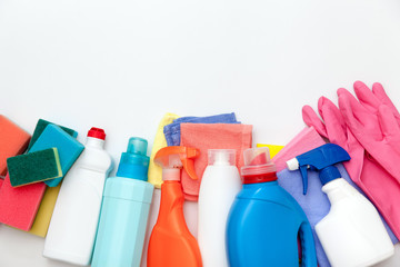 Bottles with detergent and cleaning tools on a light background.  Colorful cleaning products. Home cleaning concept. Top view, close-up