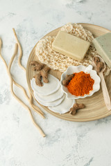 Ingredients for Face Mask with turmeric powder, spa procedures for skin health. Organic wellness treatment - curcumin powder, soap, sponge, natural massage gloves