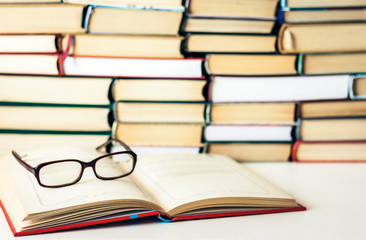 Books background, open book and glasses on white wooden table in office business background for education learning concept.