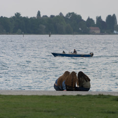 Fototapeta na wymiar Drei Freundinnen sitzen am Ufer des Sees