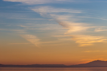 Beautiful view of Trasimeno lake (Umbria, Italy) at sunset, with orange and blue tones in the sky