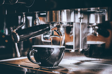 Professional Barista making fresh Espresso coffee with machine in coffee shop or cafe..