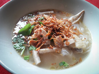 The green color of coriander and shallot topped on top of the noodle in chicken wings soup