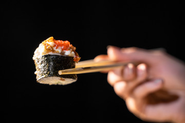 sticks keep rolls with salmon on black background