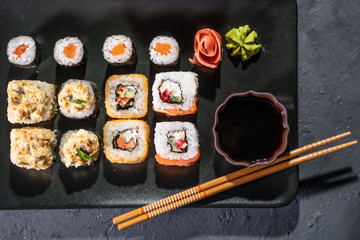 Sushi and sushi roll set on black stone table top view
