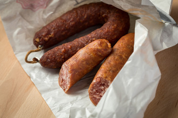 Ringwurst Salami und Bierbeißer Wurst in Wachspapier auf Vesper Holzbrett