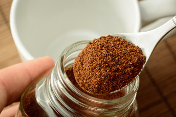 Making coffee in the morning. Taking spoon of coffee out of jar. Putting coffee to the cup
