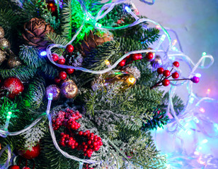 Christmas composition of pine branches, golden Christmas decorations, red berries and artificial snow.