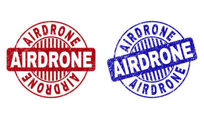 Grunge AIRDRONE round stamp seals isolated on a white background. Round seals with grunge texture in red and blue colors. Vector rubber watermark of AIRDRONE caption inside circle form with stripes.