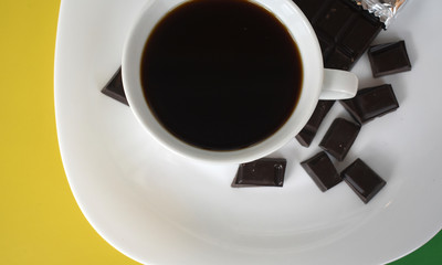 Coffee in a white Cup with chocolate slices close-up.