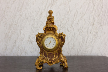 Decorative Antique table clock with a roman boy statue reading book on the top of the clock. Roman...