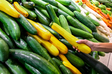 Vegetable background, fresh and shiny organic zucchinis or courgettes on a local food market, Bali island.