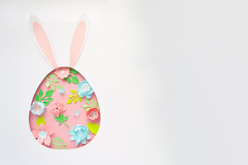 Easter egg made of paper flowers on pink background. Cut from paper.