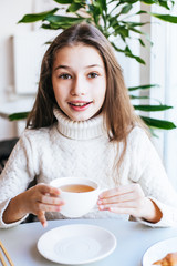 Smiling young girl having breakfast