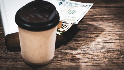US dollar banknote money stack inside the book lay on old textered wooden plank, professional financial management concept.