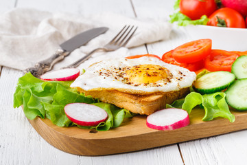 crispy toast with a fried egg and fresh arugula, a cup of coffee, breakfast in hotel room