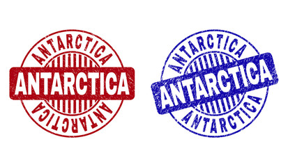 Grunge ANTARCTICA round stamp seals isolated on a white background. Round seals with grunge texture in red and blue colors. Vector rubber overlay of ANTARCTICA text inside circle form with stripes.