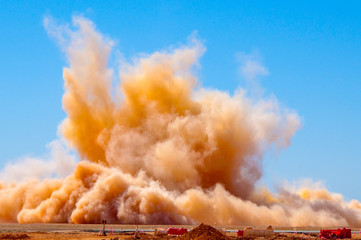 Rock dust clouds after the detonator blast on the mining site 