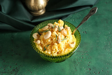 Bowl with traditional Indian food pongal on table