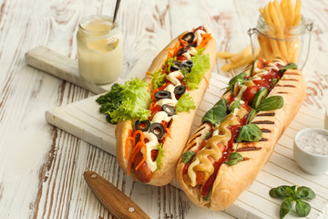 Tasty hot dogs on wooden table